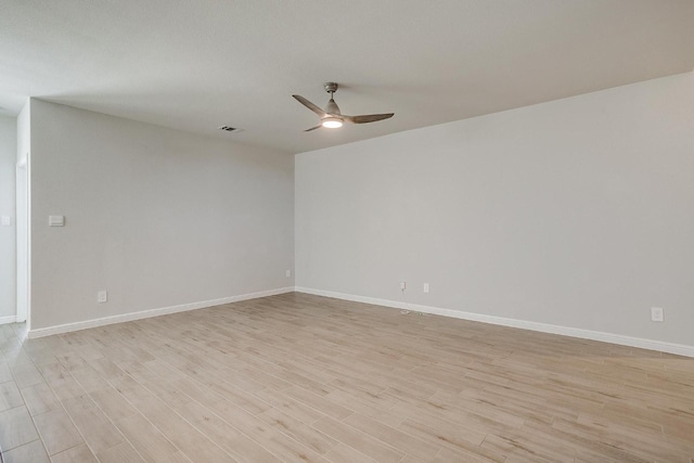 empty room with baseboards, ceiling fan, light wood finished floors, and visible vents