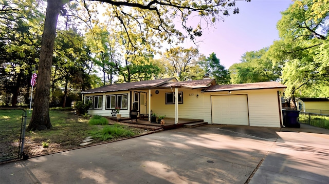 ranch-style house featuring fence, driveway, and a garage