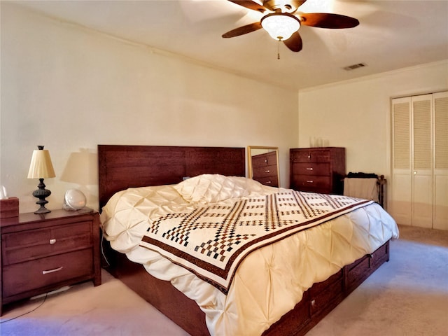 carpeted bedroom featuring a ceiling fan, crown molding, visible vents, and a closet