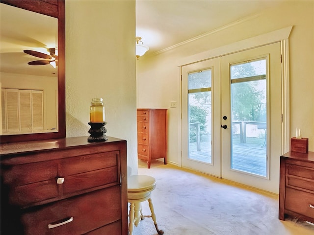 doorway to outside featuring ceiling fan, carpet floors, ornamental molding, and french doors