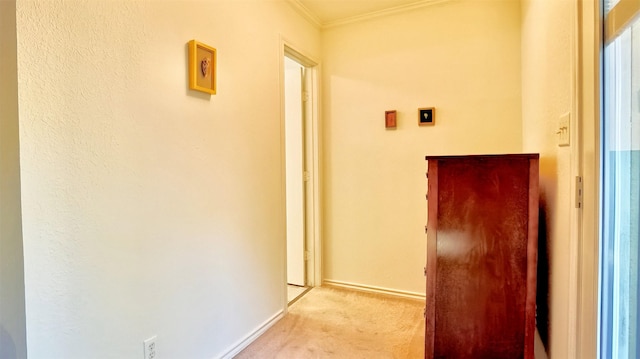 hallway with light carpet, baseboards, and crown molding