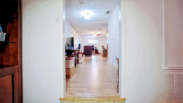 corridor featuring visible vents, light wood finished floors, and baseboards