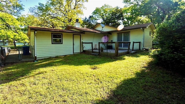 back of property with a gate, a lawn, a chimney, and fence