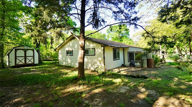back of property with a storage shed, a patio area, and an outdoor structure