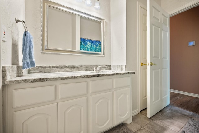 full bath featuring tile patterned flooring, baseboards, and vanity