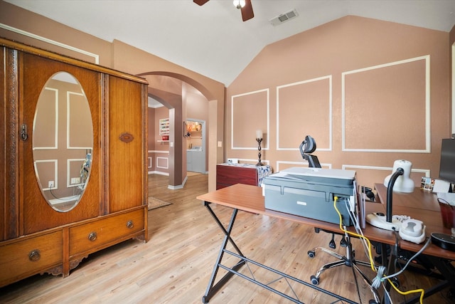 office space with lofted ceiling, visible vents, arched walkways, washer / dryer, and ceiling fan