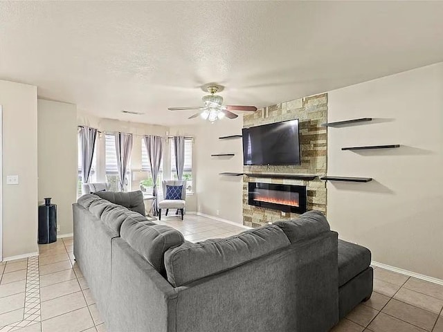 130 Walnut Dr, Seagoville, TX 75159 - living room with a ceiling fan, a textured ceiling, light tile patterned floors, baseboards, and a fireplace