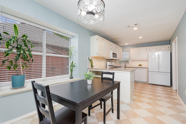 900 Valley View Dr, Lewisville, TX 75067 - dining space with visible vents, an inviting chandelier, baseboards, light floors, and a textured ceiling