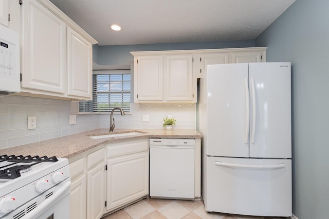 900 Valley View Dr, Lewisville, TX 75067 - kitchen featuring white cabinets, light stone counters, a sink, white appliances, and backsplash