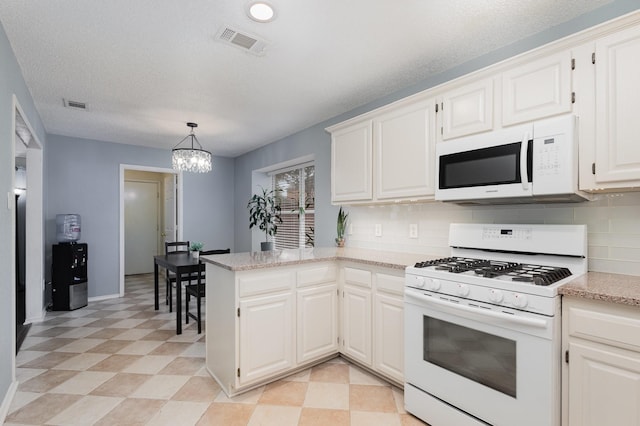 900 Valley View Dr, Lewisville, TX 75067 - kitchen featuring a peninsula, backsplash, white appliances, and visible vents