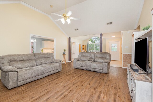 900 Valley View Dr, Lewisville, TX 75067 - living room featuring visible vents, crown molding, light wood-type flooring, high vaulted ceiling, and ceiling fan with notable chandelier