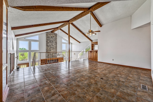 unfurnished living room with a textured ceiling, plenty of natural light, visible vents, and lofted ceiling with beams