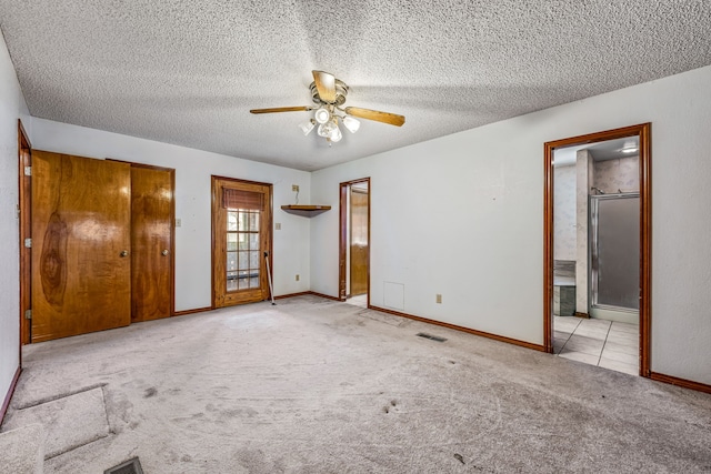 unfurnished bedroom with baseboards, carpet flooring, a textured ceiling, and connected bathroom