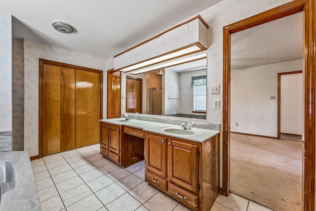 full bath with wallpapered walls, a sink, double vanity, and tile patterned floors
