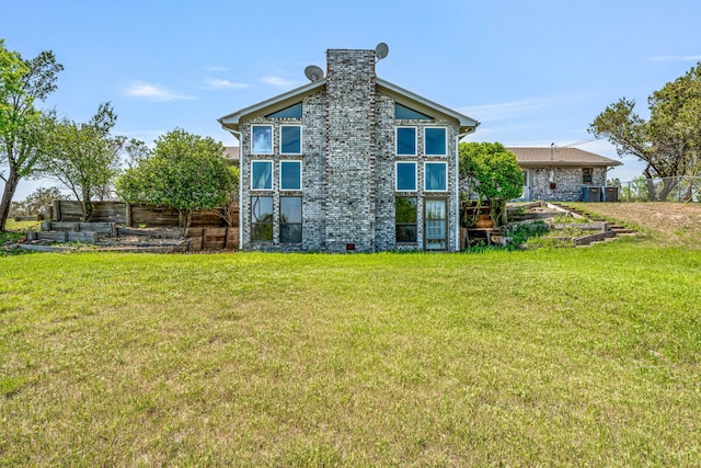 back of house featuring a lawn and fence