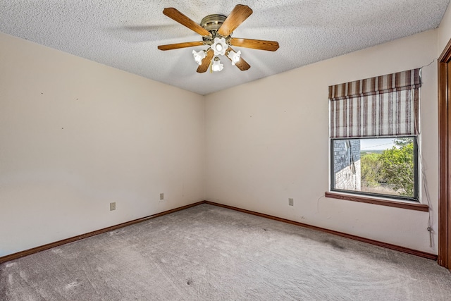 carpeted spare room with ceiling fan, baseboards, and a textured ceiling