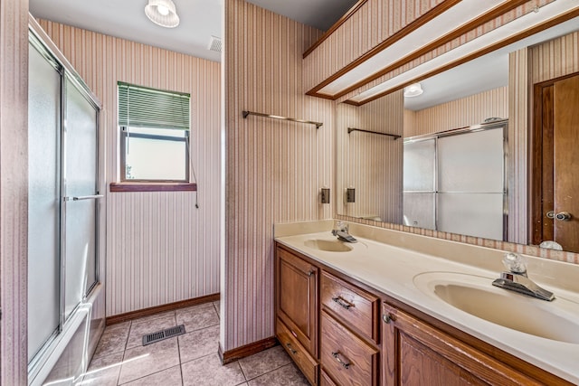 bathroom featuring wallpapered walls, double vanity, visible vents, and a sink