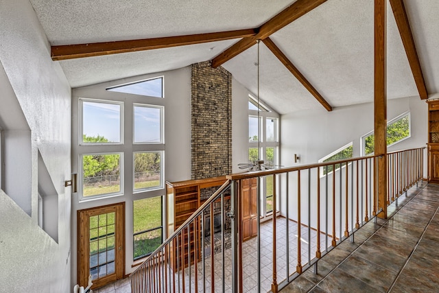 hallway featuring beamed ceiling, a textured ceiling, and high vaulted ceiling