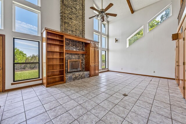 unfurnished living room with high vaulted ceiling, a ceiling fan, a brick fireplace, and light tile patterned flooring