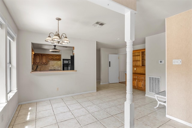 unfurnished dining area featuring baseboards, visible vents, and light tile patterned floors