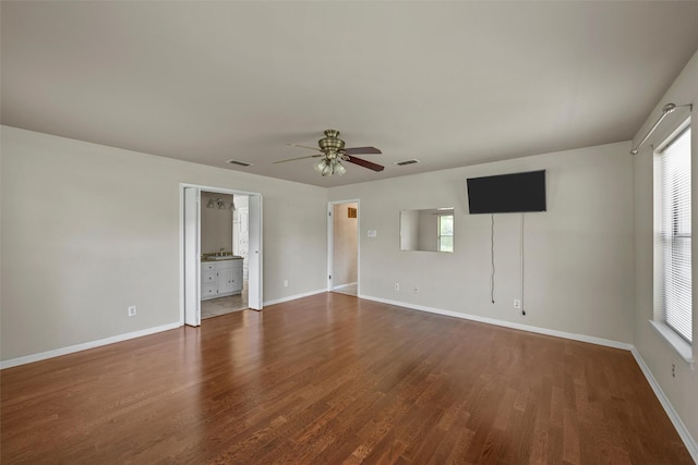 unfurnished room featuring ceiling fan, wood finished floors, visible vents, and plenty of natural light
