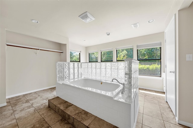 bathroom featuring visible vents, a garden tub, and baseboards