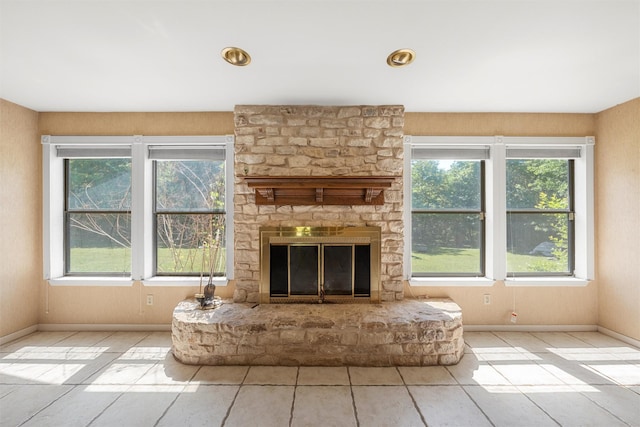 unfurnished living room featuring baseboards and a fireplace