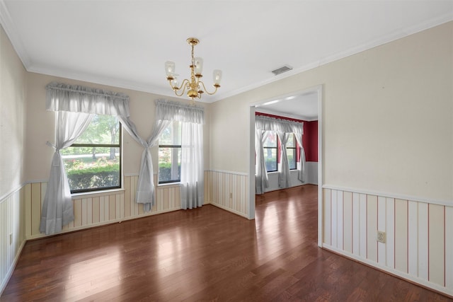unfurnished dining area featuring wood finished floors, visible vents, a notable chandelier, and wainscoting