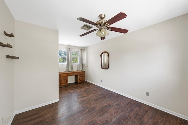 spare room featuring baseboards, a ceiling fan, dark wood-type flooring, and visible vents
