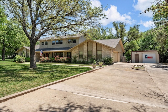 traditional home with central AC, a front lawn, brick siding, and a garage