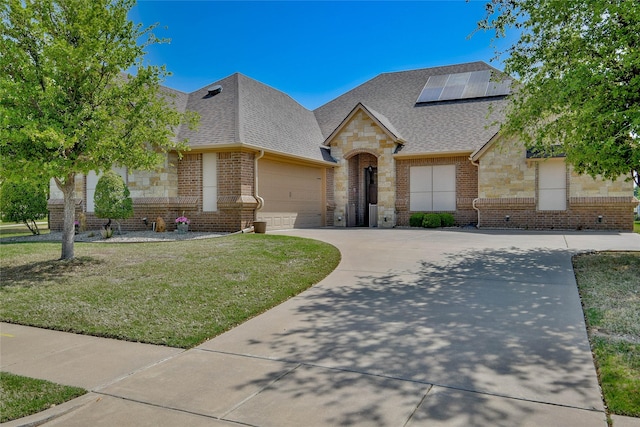 1601 Harbor Lakes Dr, Granbury, TX 76048 - french country home with stone siding, a shingled roof, concrete driveway, a front lawn, and a garage
