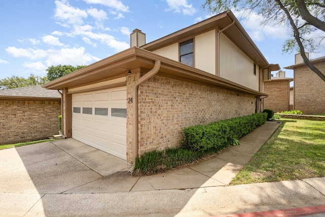 24 Cedar Ln, Bedford, TX 76021 - view of home's exterior with concrete driveway, a chimney, brick siding, and a garage