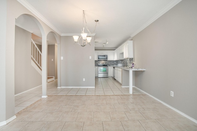 24 Cedar Ln, Bedford, TX 76021 - kitchen with appliances with stainless steel finishes, arched walkways, backsplash, light tile patterned flooring, and crown molding