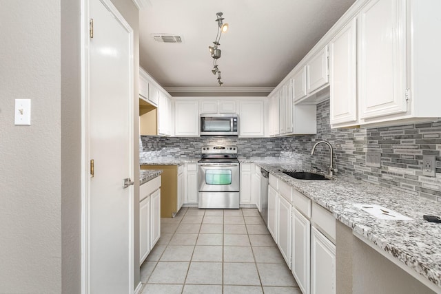 24 Cedar Ln, Bedford, TX 76021 - kitchen with stainless steel appliances, a sink, decorative backsplash, light tile patterned floors, and light stone counters