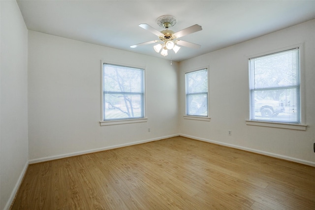 empty room with light wood finished floors, baseboards, and ceiling fan