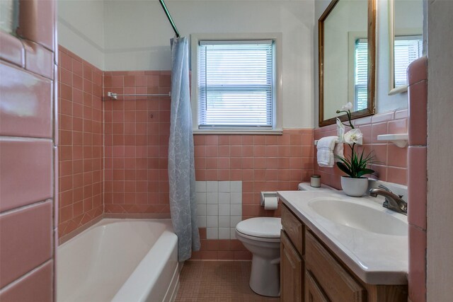 bathroom featuring tile patterned floors, vanity, shower / tub combo with curtain, a wainscoted wall, and toilet