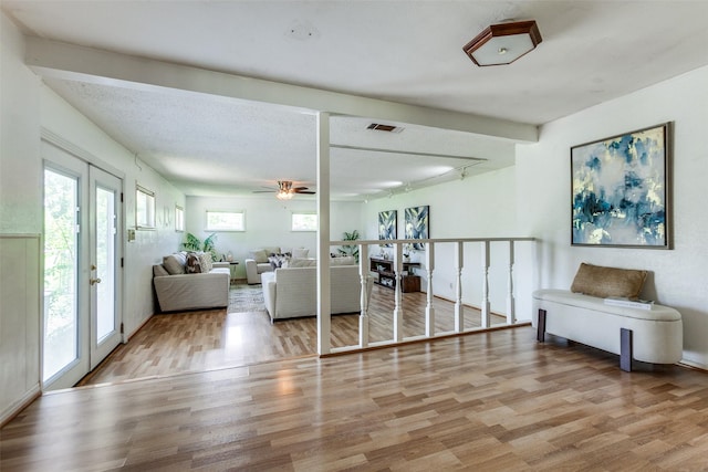 living area featuring a ceiling fan, wood finished floors, and visible vents