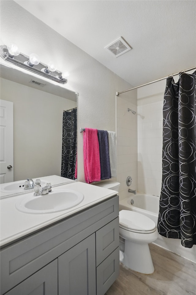 bathroom with wood finished floors, visible vents, vanity, and shower / bath combo with shower curtain