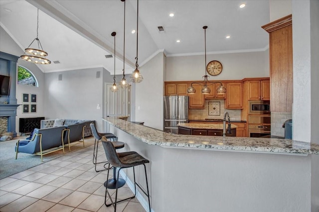 kitchen with high vaulted ceiling, light stone counters, brown cabinetry, stainless steel appliances, and visible vents