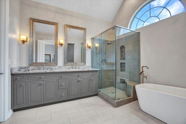 bathroom featuring a soaking tub, a sink, double vanity, and a stall shower