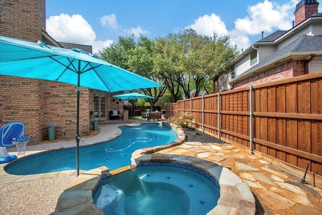 view of pool with french doors, a pool with connected hot tub, a fenced backyard, and a patio