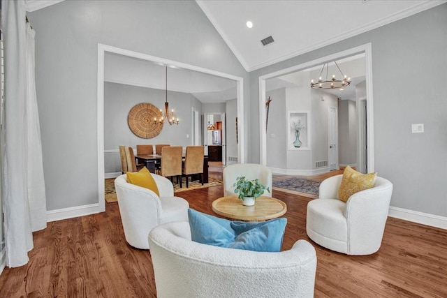 living room with baseboards, wood finished floors, visible vents, and a notable chandelier