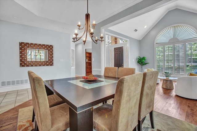 dining area featuring lofted ceiling, visible vents, a notable chandelier, and plenty of natural light