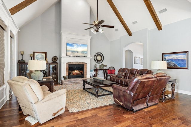 living area with high vaulted ceiling, ceiling fan, arched walkways, and visible vents