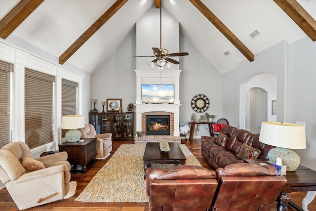 living area featuring dark wood-style floors, visible vents, beamed ceiling, high vaulted ceiling, and ceiling fan