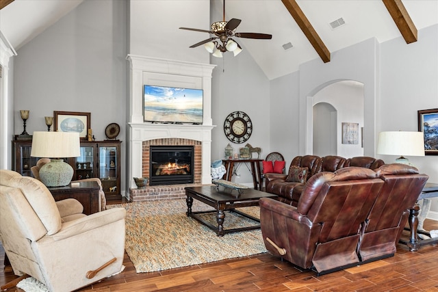 living area featuring arched walkways, wood finished floors, a ceiling fan, and high vaulted ceiling