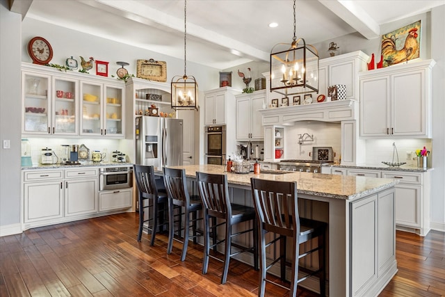 kitchen with tasteful backsplash, an inviting chandelier, white cabinets, appliances with stainless steel finishes, and beam ceiling