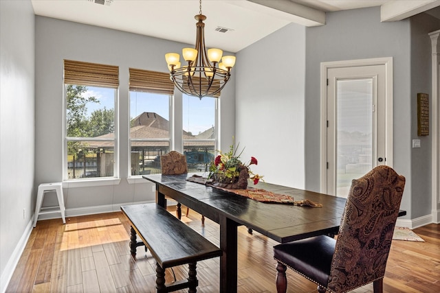 dining room with wood finished floors, visible vents, beam ceiling, baseboards, and a chandelier