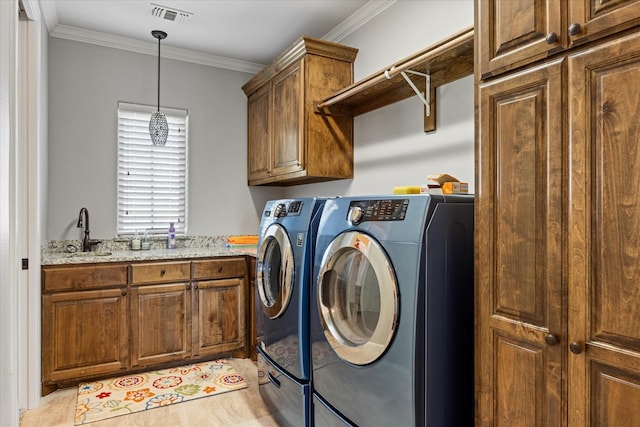 laundry room with crown molding, a sink, washer and dryer, cabinet space, and visible vents