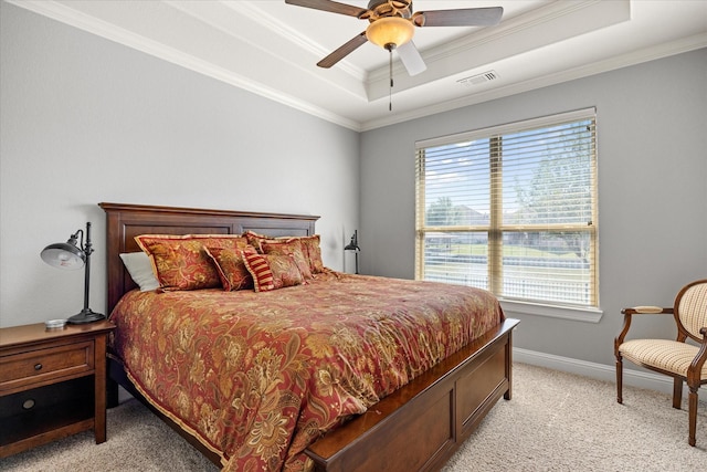bedroom with light colored carpet, ornamental molding, a tray ceiling, and visible vents